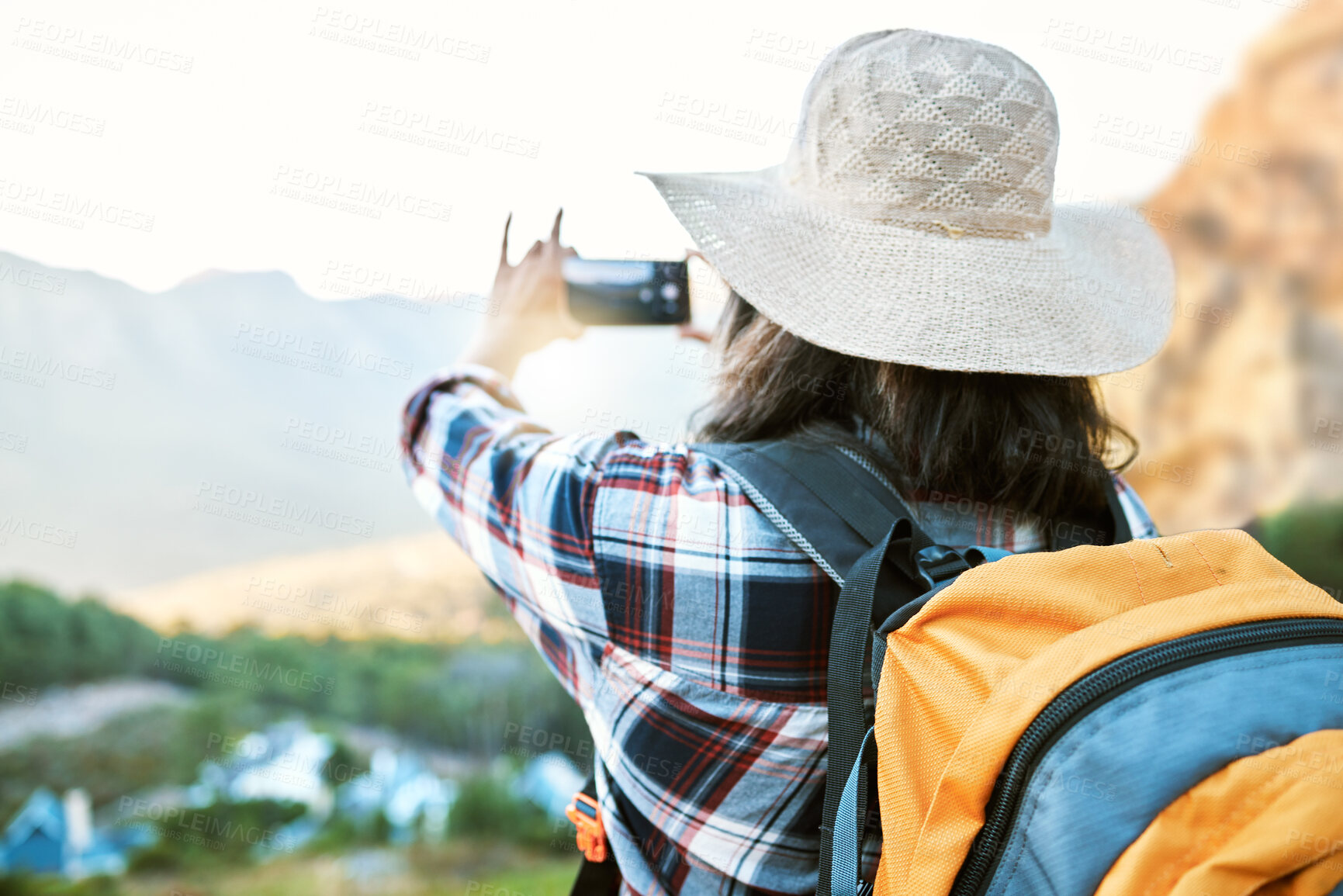 Buy stock photo Hiking woman taking photo on adventure with phone in nature, making memories on hike and enjoying the beautiful view in the countryside on vacation. Person taking pictures of the natural environment