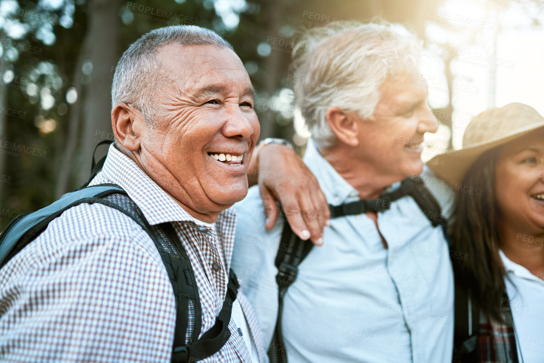 Buy stock photo Hiking, adventure and exploring with a carefree and excited male hiker with his senior friends outdoors. Enjoying a hike or walk in the forest or woods as a group of retired people for leisure