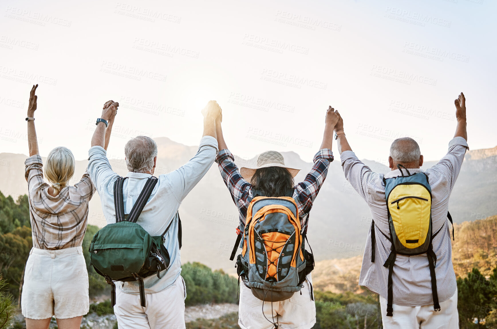 Buy stock photo Hiking group, celebration and success on mountain peak after climbing and walking up remote hills. Cheering, motivated or proud mature friends with arms up on adventure in remote eco nature landscape