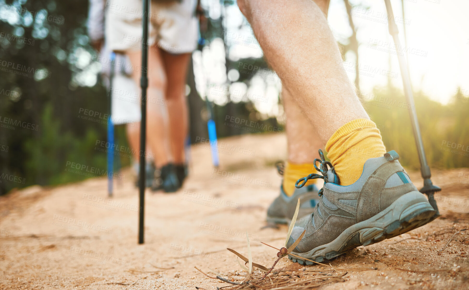 Buy stock photo Feet or shoes walking, trekking and hiking on a trail up a mountain with sticks and poles. Closeup of group of adventurous hikers or friends exploring rugged path on a mountain in nature