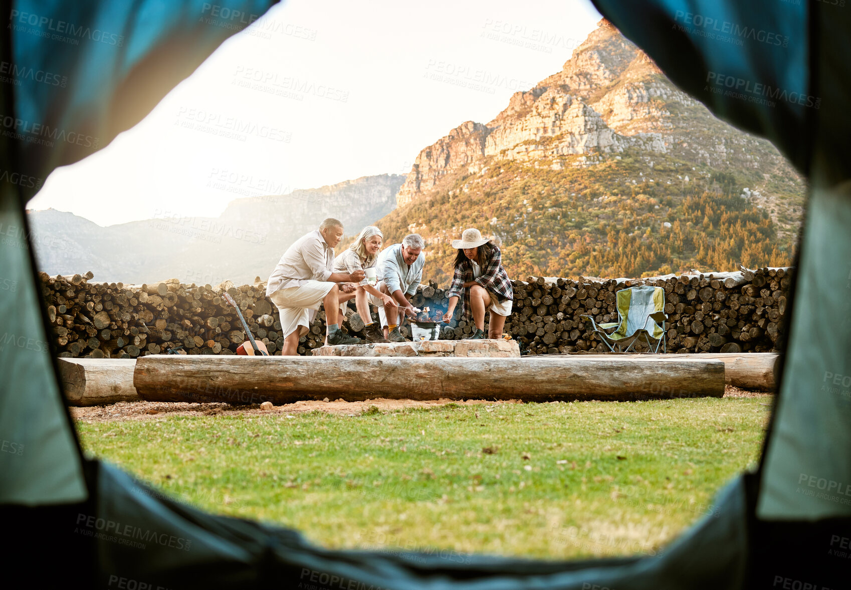 Buy stock photo People camping with a tent and roast marshmallows on a campfire enjoy outdoors, nature and the wild. Fresh air, adventure and travel lifestyle campers on a campsite relax and bond on wellness retreat