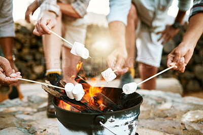 Buy stock photo Melting marshmallows by a fire on a nature getaway vacation, group bonding and relaxing together outside with candy in the mountain. People on a wellness holiday enjoying freedom and delicious food