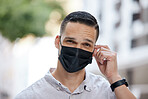 Freedom, end of covid and man removing face mask after corona virus with bokeh urban city. Trust and compliance in post covid 19 portrait or headshot of young person free after getting vaccine