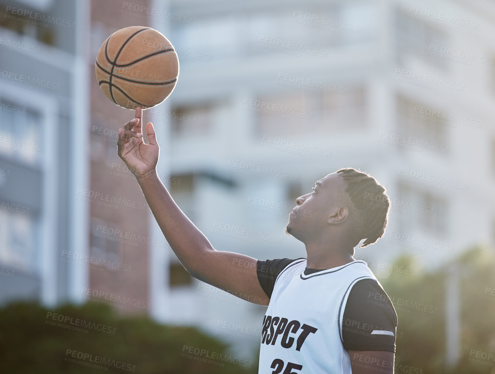 Buy stock photo Basketball player, athlete and sports man with skill spinning a ball on his finger during training for game, match or competition outdoor. Black man with motivation, goal and mindset prepared to win