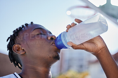 Buy stock photo Water, hydration and healthy lifestyle of a sporty black man drinking water from a bottle, enjoying a refreshing drink. African athlete restore electrolytes while being active and exercise outside