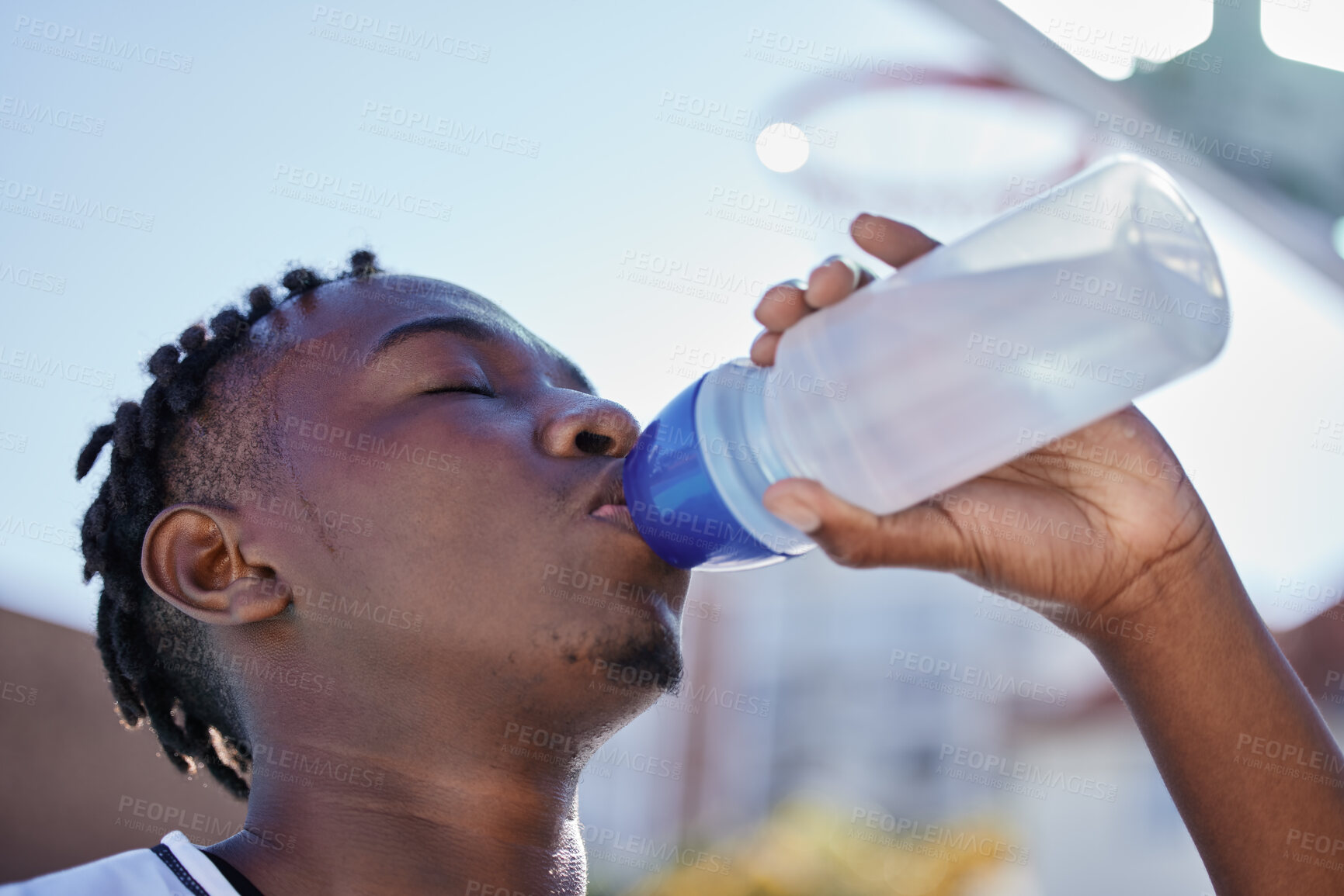 Buy stock photo Water, hydration and healthy lifestyle of a sporty black man drinking water from a bottle, enjoying a refreshing drink. African athlete restore electrolytes while being active and exercise outside