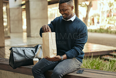 Buy stock photo Office employee with a coffee, a paper sandwich bag and a smile, on a bench for a break from his busy work schedule. Happy, hungry businessman, time to eat, with his food and drink outside for lunch.