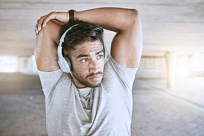 Buy stock photo Fitness man training with headphones stretching, listening to music or a motivation podcast with lens flare in urban city. Sports person with an online audio for his warmup morning workout exercise