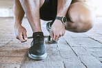 Shoes, fitness and exercise with a sports man tying his laces for a cardio and endurance workout in the city. Training, running or exercise and an athlete with a motivation for health and wellness