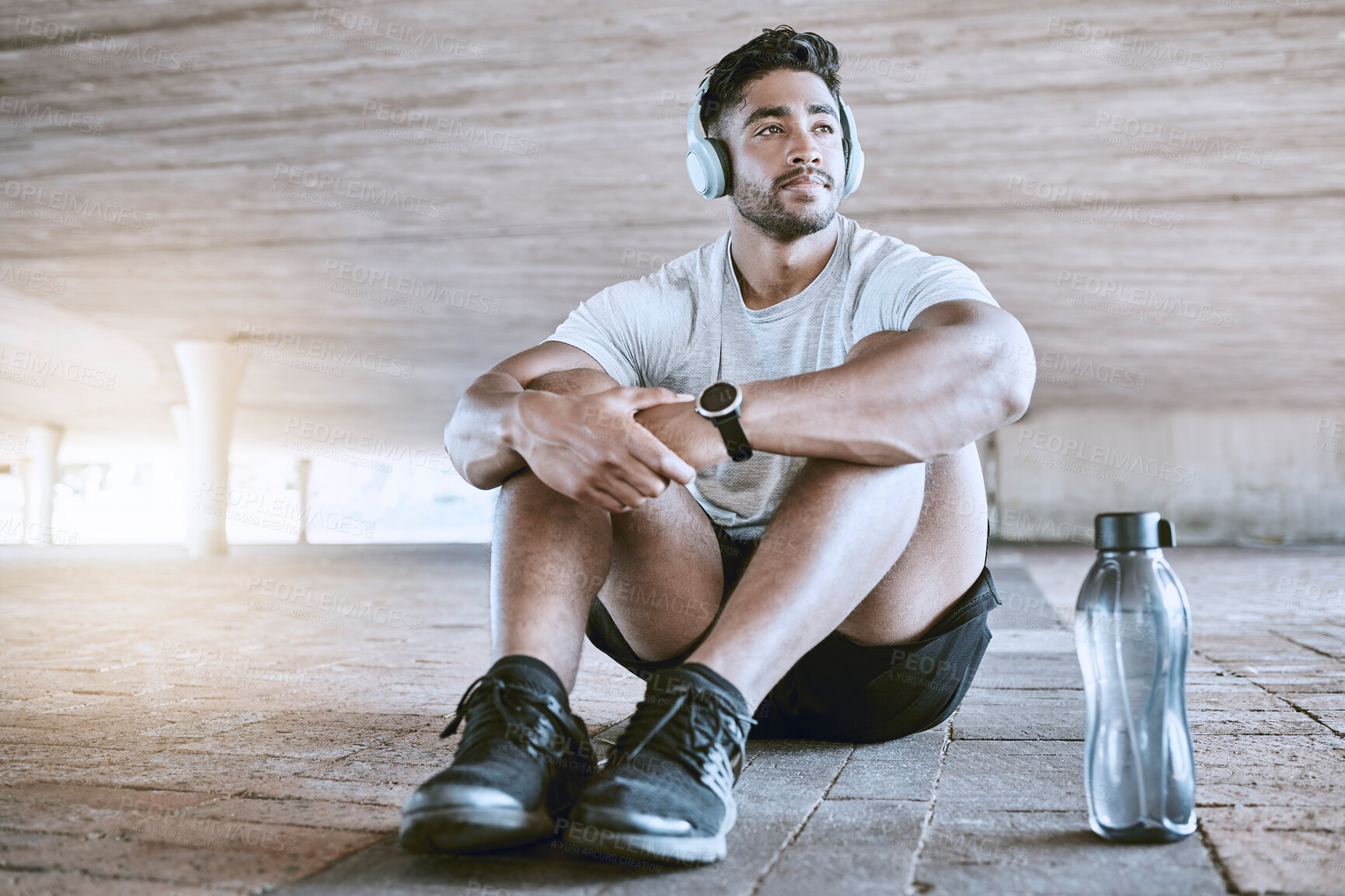 Buy stock photo Athlete with headphones and water bottle on a relax break listening to music after his training exercise in the city with lens flare. Young sports man with audio fitness technology and workout gear