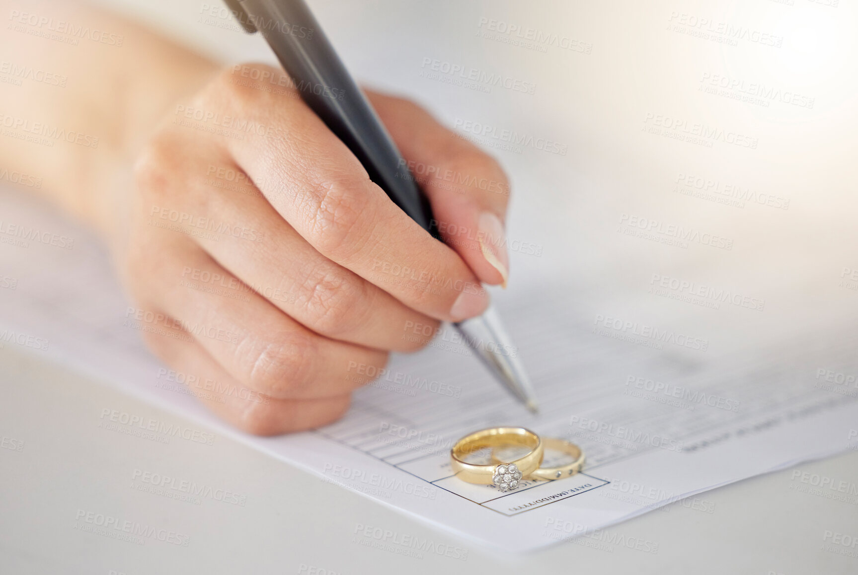 Buy stock photo Woman hand signing legal divorce documents, deal or paper contract in a lawyer office with ring placed on table. Person writing signature on marriage paperwork after agreement at family law office