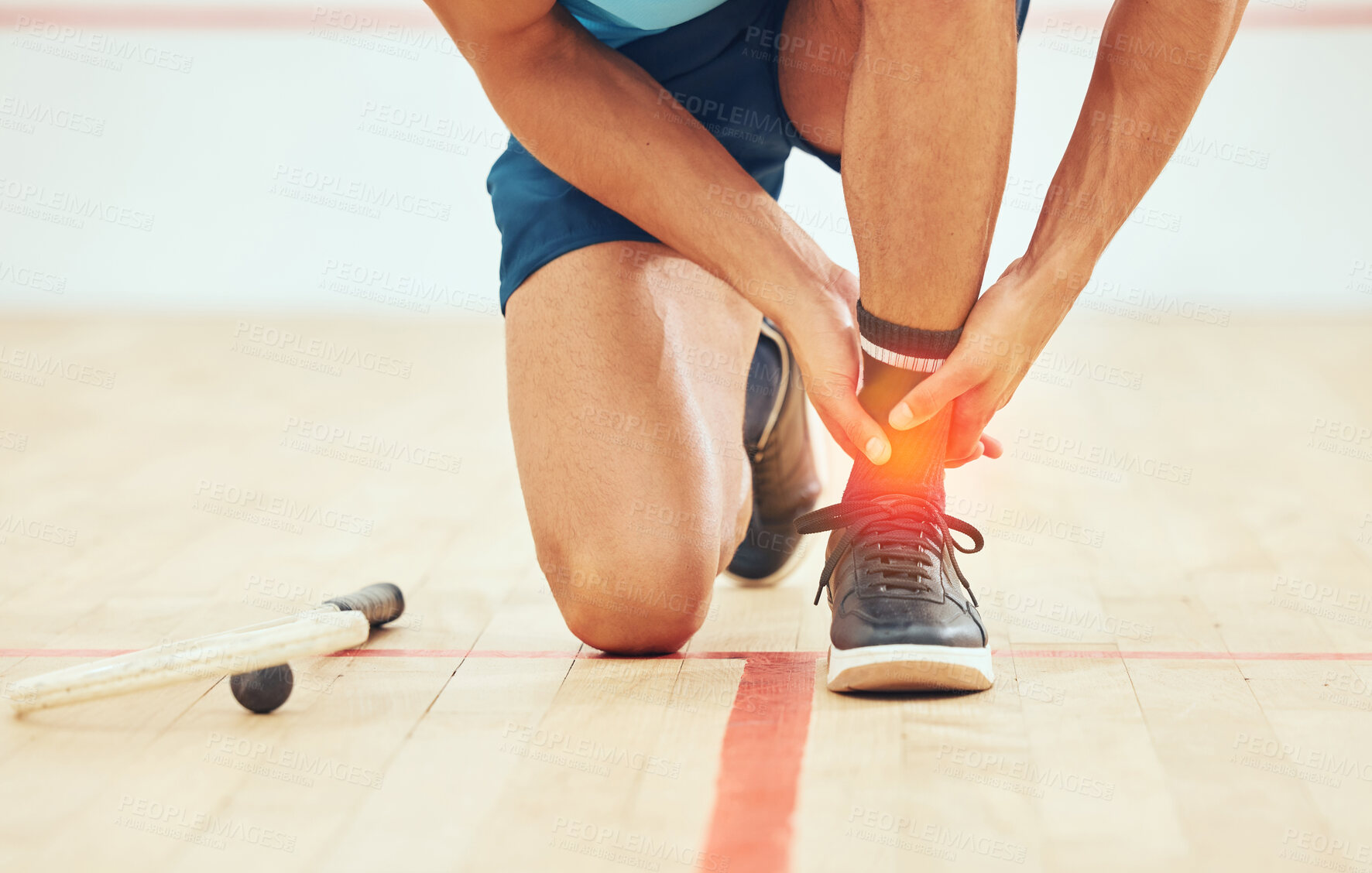 Buy stock photo Unknown squash player suffering from ankle sprain during court game. Fit active mixed race athlete kneeling and feeling pain in achilles tendon. Cgi and special effects on sports injury after playing