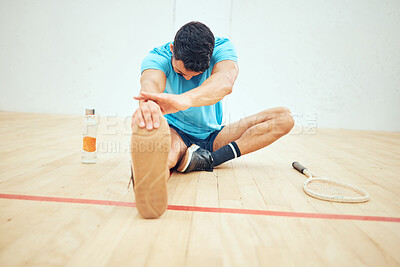 Buy stock photo Full length of squash player stretching before playing court game with copyspace. Fit active mixed race athlete sitting alone and getting ready for training practice in sports centre. Sporty hispanic