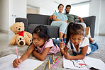 Children drawing, notebook education and parents in living room to relax with kids on floor. Girl siblings writing, studying and doing homework in the lounge with mother and father in family home