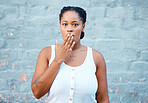 Shocked black woman, hand and worry in silence for secret against a wall background. Portrait of African American female covering mouth in concerned facial expression for negative news