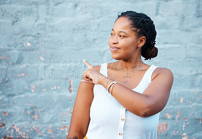 Buy stock photo Black woman pointing finger to show advertising, promo or commercial mockup, marketing space on blue wall outdoor gen z, youth lifestyle. African girl or student with hand sign to information mock up