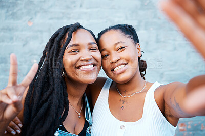 Buy stock photo Smile, friends and selfie with black woman against wall with phone for social media, happy and peace sign. Digital, internet and portrait of girl in urban city for freedom, support or mobile together