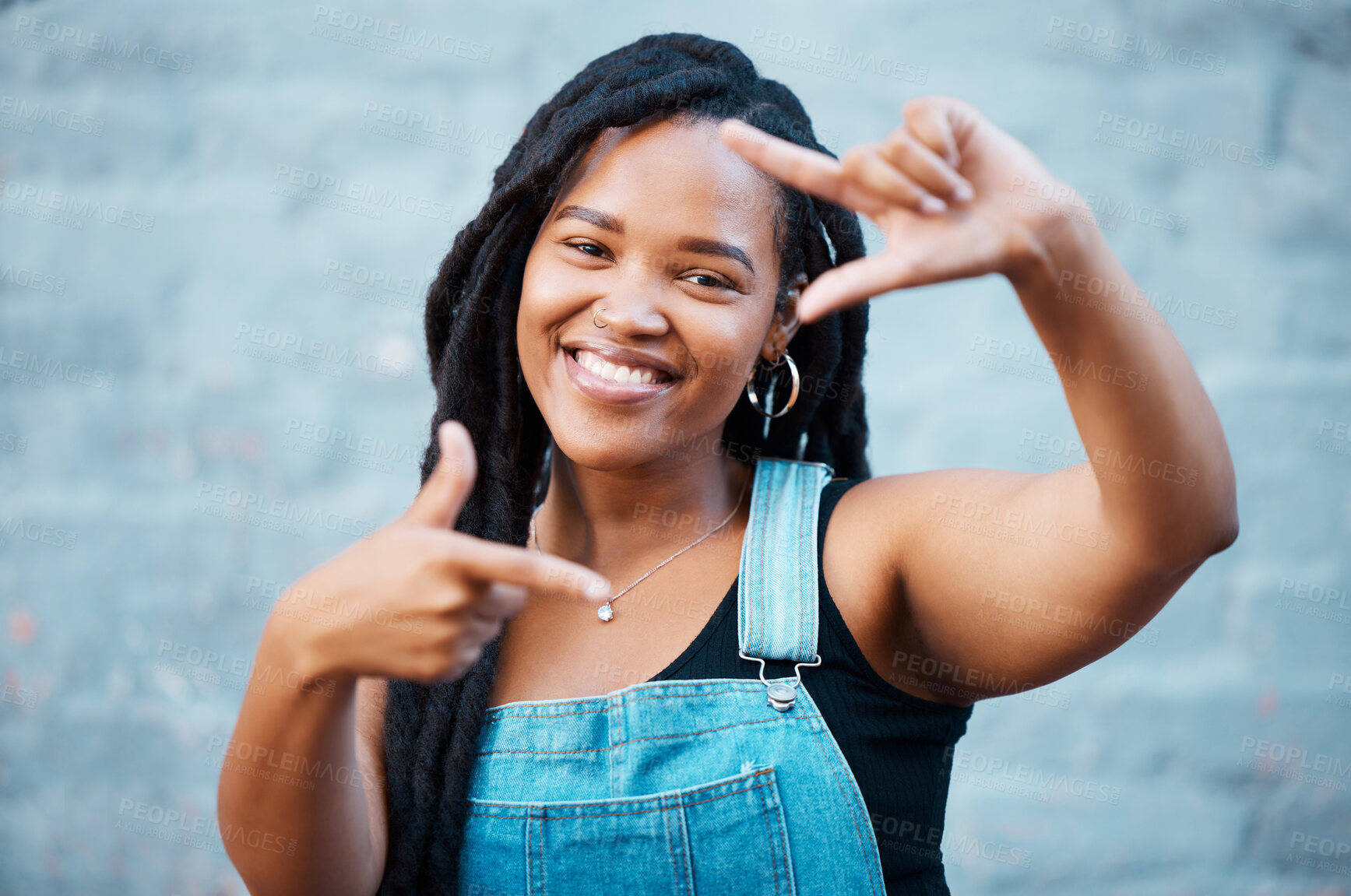 Buy stock photo Black woman, hands and finger frame showing smile, happiness and face against city building wall, mockup space or outside in Atlanta. Portrait of female model with fun or playful gesture for beauty 