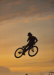 Mountain bike, cyclist and fitness jump at sunset in Colorado countryside nature in workout, exercise or training. Danger risk, extreme bmx sports or freedom cycling man in sunrise with stunt energy