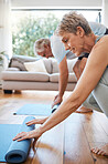 Senior couple, rolling yoga mat and home workout, fitness and exercise on living room floor. Elderly people on lounge ground for pilates training, healthy lifestyle and balance body wellness together