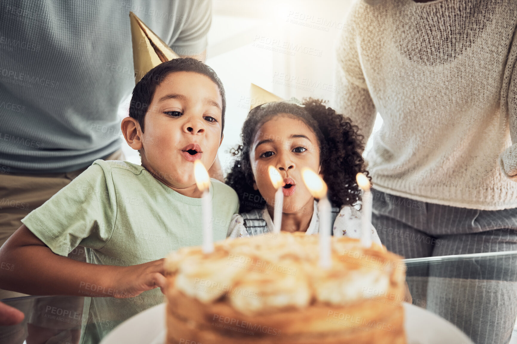 Buy stock photo Children, birthday cake and blowing candles in celebration event, fun party or Brazilian family social reunion with parents. Boy, girl or kids with sweet dessert food in house or home with mom or dad