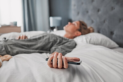 Buy stock photo Phone, bed and woman sleeping in a bedroom, exhausted and suffering with mental health problem. Tired, lazy and procrastination by depressed lady ignoring alarm, experience fatigue from insomnia
