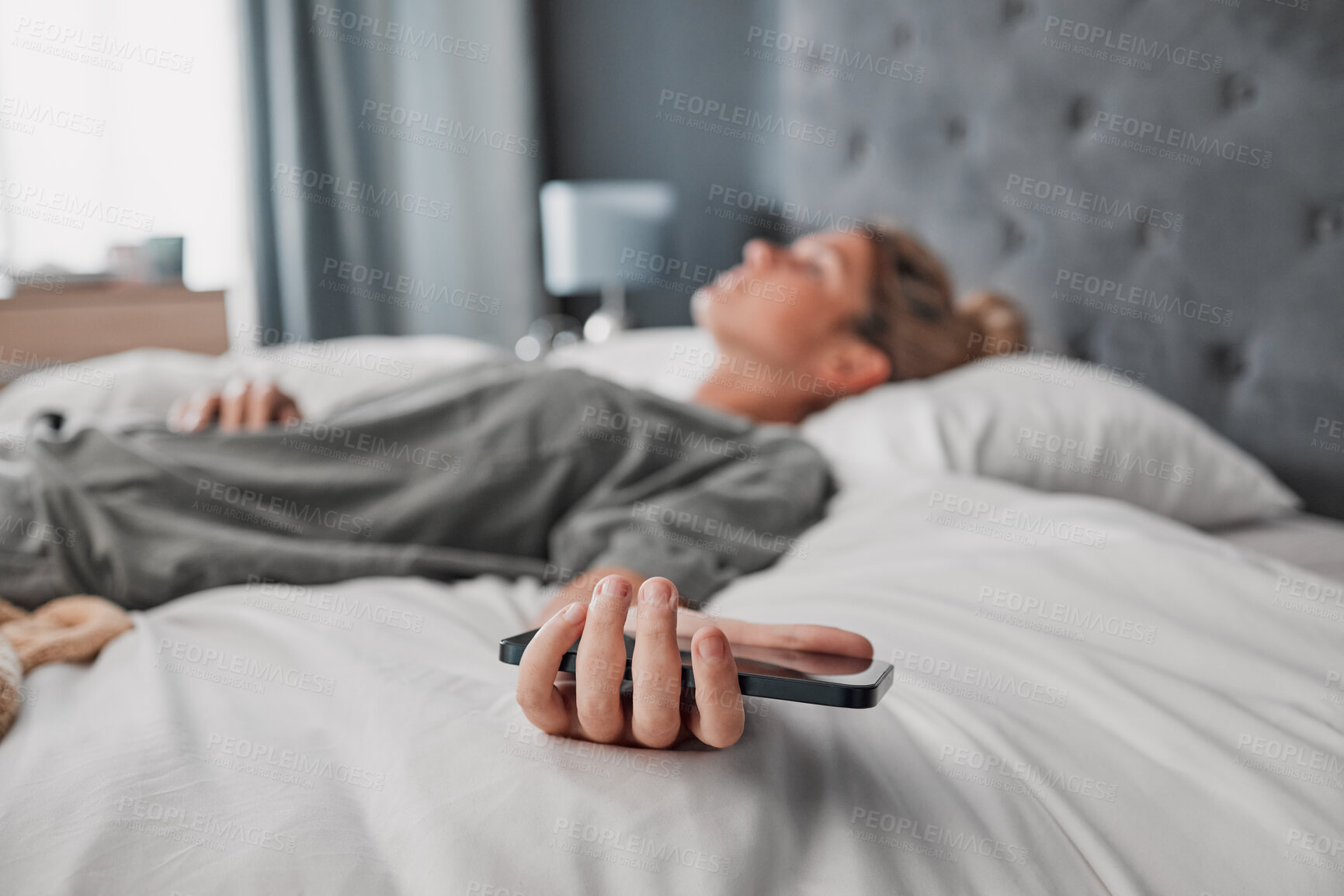 Buy stock photo Phone, bed and woman sleeping in a bedroom, exhausted and suffering with mental health problem. Tired, lazy and procrastination by depressed lady ignoring alarm, experience fatigue from insomnia