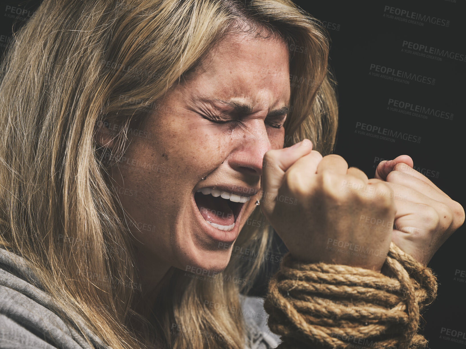 Buy stock photo Danger, scared and horror woman scream for help with hands tie and trapped by rope on black studio background. Violence, sad or anxiety female with crime, fear and prisoner, crying for mental health