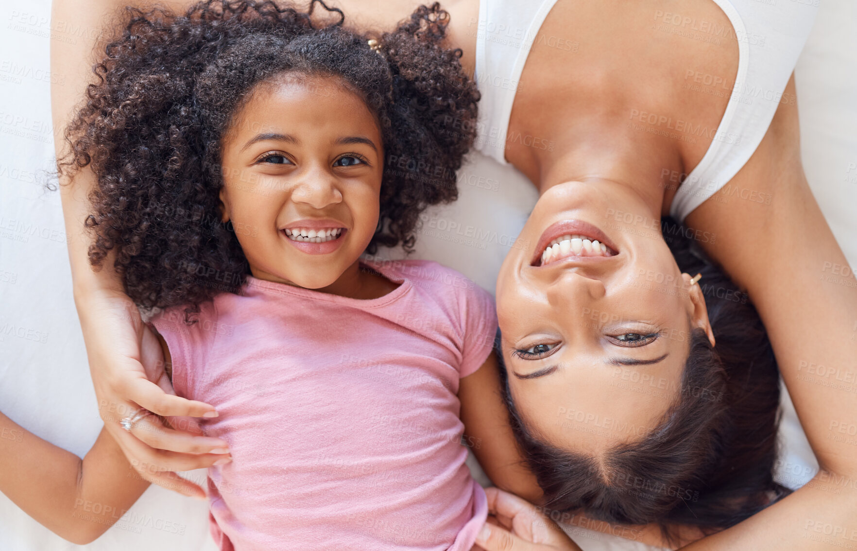 Buy stock photo Top view, mom and girl bonding while lying in house, family home or hotel bedroom in trust, love and support. Portrait, smile and happy child with woman and Mexican parent in mothers day celebration