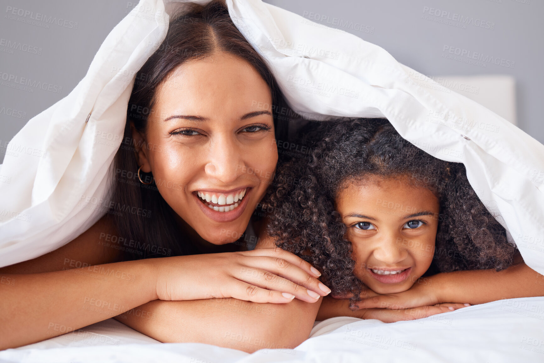 Buy stock photo Children, family and bedroom with a girl and mother in bed under a blanket together for love or care in the home. Kids, trust and happy with a woman her daughter in the house to relax in the morning
