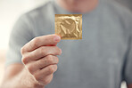 Condom in man hand for safe sex, sexual safety and hiv awareness zoom. Person with male contraceptive product for sexual risk prevention, healthcare and caution for security, trust and love choice