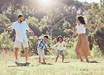 Freedom, happy family and fun in a park with black children and parents bonding and playing on grass. Love, energy and kids excited and happy while enjoying a fun dancing activity with mom and dad
