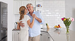 Elderly, couple and dance in home kitchen together for fun, bonding and romance. Senior man, woman and retirement dancing in house to show love, happiness and care with smile on face in romantic time