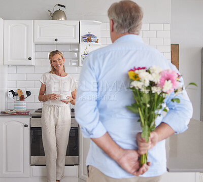Buy stock photo Elderly, couple and flowers in kitchen for surprise, love and romance in their house. Woman, man and retirement together with bouquet to celebrate marriage, birthday or anniversary in their home