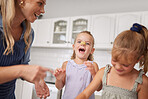 Home kitchen, children play while cooking with happy mother and funny family time learning to bake. Crazy girl child with flour dough on nose, laugh together helping mom smile and sweet kids have fun