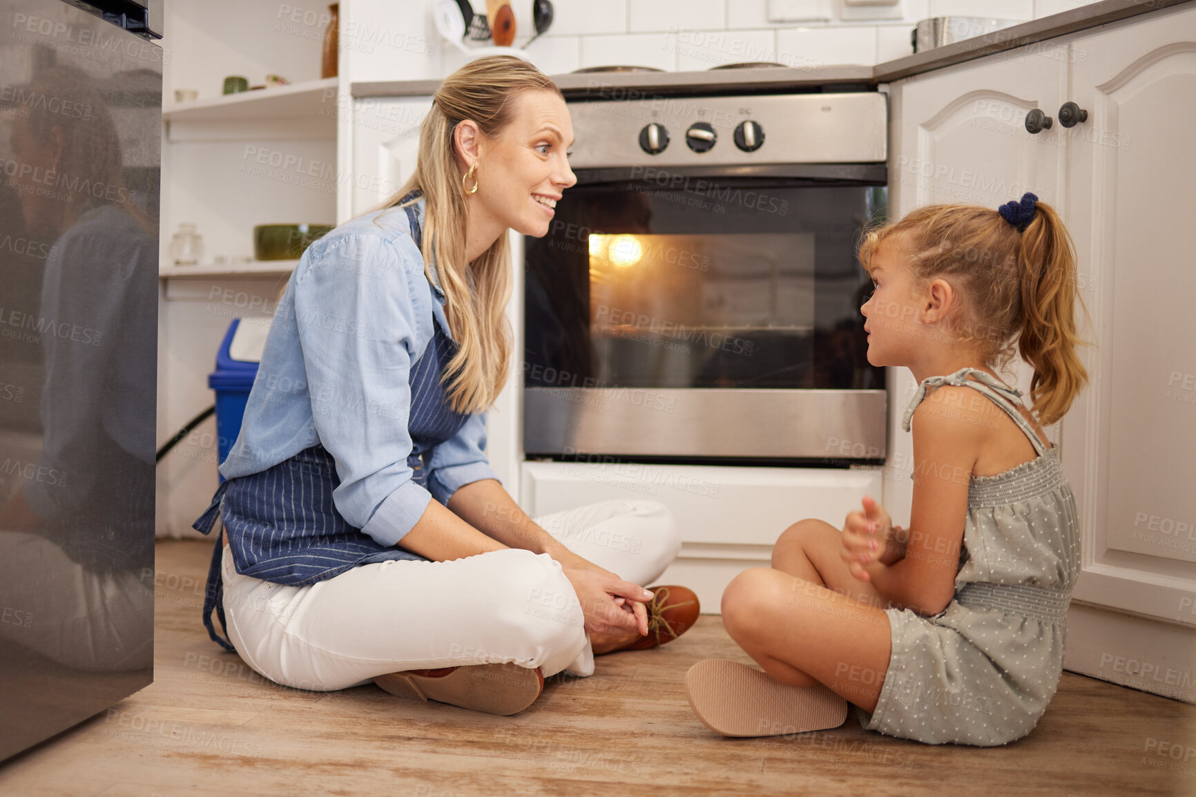 Buy stock photo Cooking, mom and child on kitchen floor in house talk and relax while waiting for food in the oven. Canada mother enjoying happy food preparation leisure break with young daughter in family home.