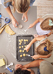 Baking, family and girl children learning to bake cookies in kitchen at home from above with mom, dad and sister. Man, woman and kids having fun with dough, cooking and food together making pastry