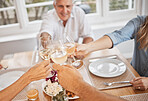 Family, wine and toast in celebration of of a holiday or good news at table, happy and cheerful in their home. Relax, smiling and excited people cheers before lunch, hungry and ready to share a meal
