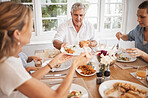 Family, food and eating with a senior man at the dining room table with his relatives for a meal during a visit or celebration event. Happy, together and fresh with a hungry group of people at home