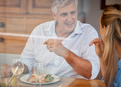 Buy stock photo Food, family and father and daughter bonding at a table, talking and looking happy and cheerful. Love, nutrition and conversation by parent and woman relax and share meal in their home with wine 