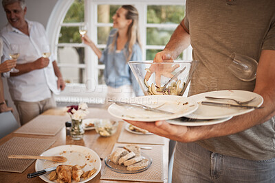 Buy stock photo Lunch, family and man cleaning dishes from table after eating meal. Clean up, packing away and clearing plates from dinner table after family lunch together. Household, helping and dinner at home