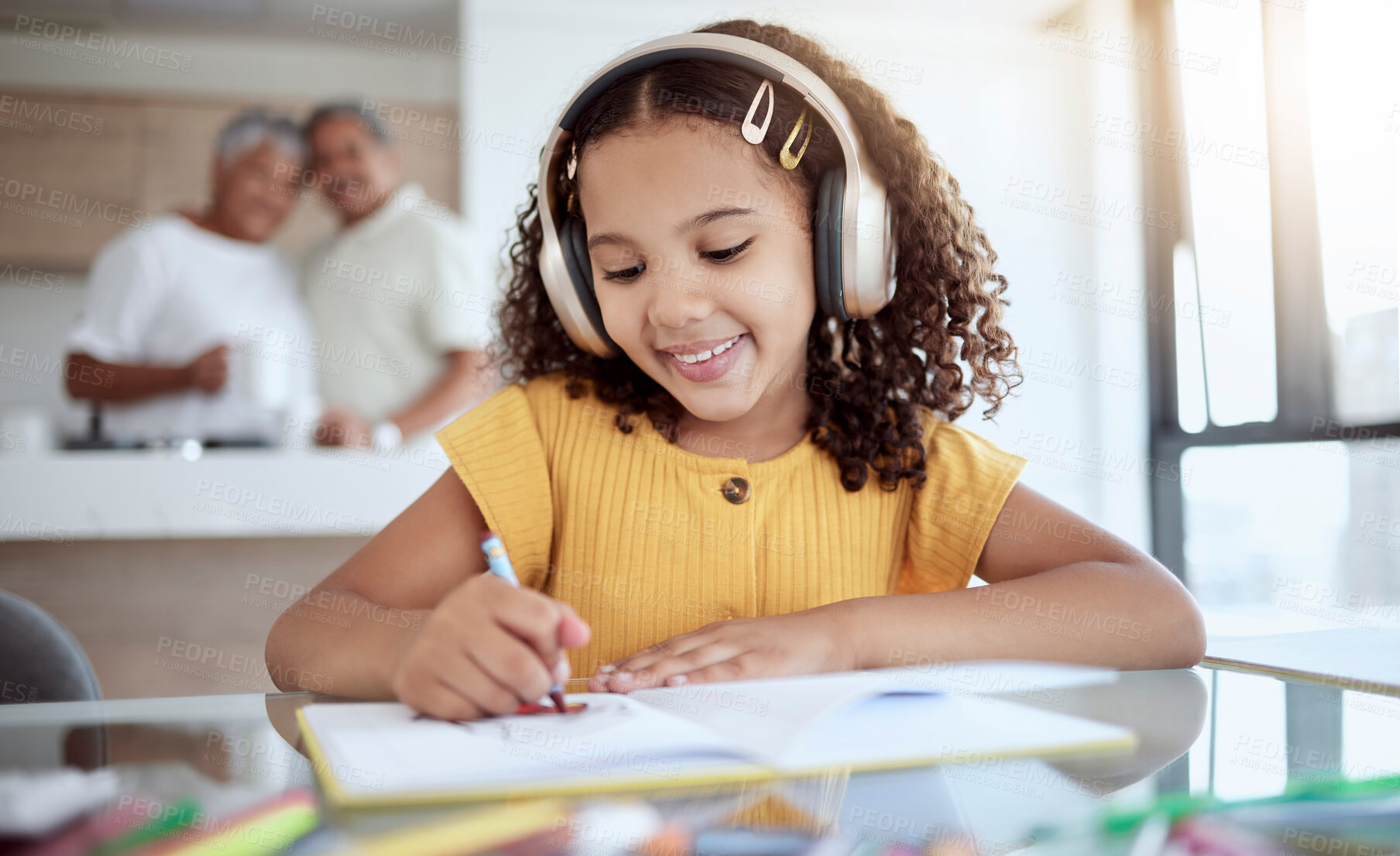 Buy stock photo Girl, homework and music while drawing in book for school, assignment or fun in family home. Child, education and notebook for learning with headphones for audio, radio or streaming in house at desk