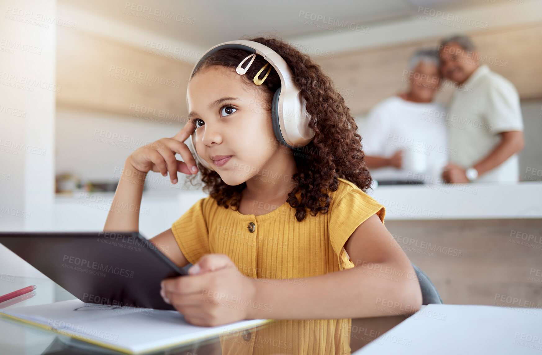 Buy stock photo Children, tablet and education with a girl thinking while distance learning using headphones for home school. Idea, study and technology with a female student in her grandparents house to learn