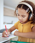 Girl, home and music while drawing in book for homework, assignment or fun in home. Child, writing and notebook while creative with headphones for audio, radio or streaming with homeschool in house
