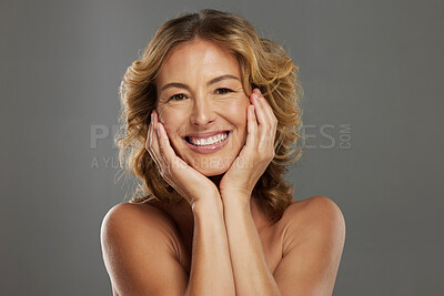 Buy stock photo Woman, smile and skincare with hands on face for health, beauty and happiness in cosmetics studio. Mature model, skin and smiling for wellness, facial and anti-aging in portrait with grey background