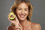 Skincare, avocado and smile on face of woman with fruit in hand for health, wellness and care. Model, skin and happy with avo in hand for healthy body, hair and beauty with facial product from nature