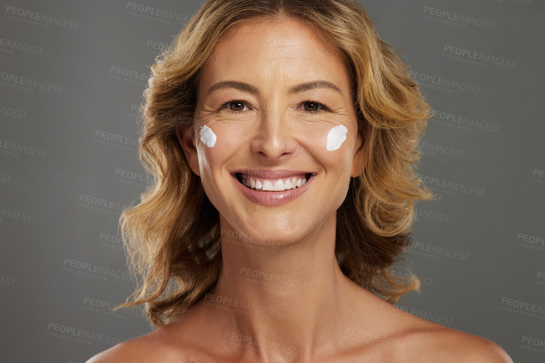 Buy stock photo Face cream, mature skincare and woman with beauty from cosmetics against a grey mockup studio background. Portrait of a happy and healthy model with natural dermatology sunscreen for wellness