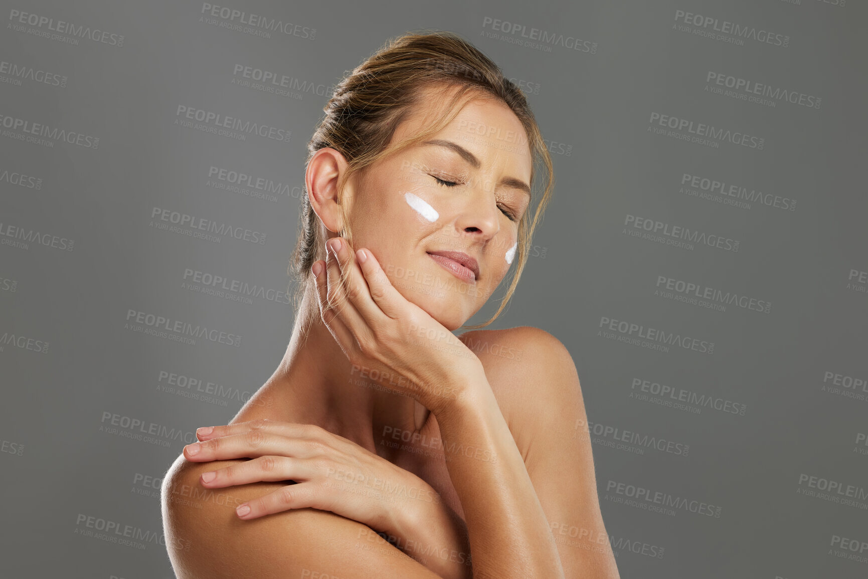 Buy stock photo Skincare, beauty cream and woman with a face cream product against a grey mockup studio background. Happy and satisfied model with cosmetics for skin, body wellness and cosmetology or dermatology