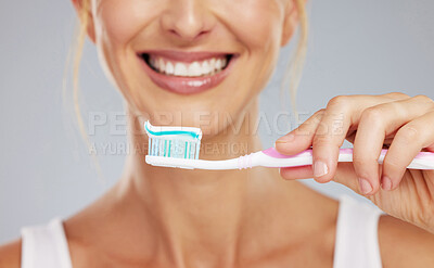 Buy stock photo Toothpaste, hand and toothbrush in morning smile with clean teeth, wellness and dental healthcare in mockup studio background. Zoom of mouth cleaning, cosmetic beauty and healthy self care routine
