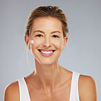 Beauty, skincare and face with a mature woman in studio on a gray background for wellness and healthcare. Cosmetics, skin and body care with a happy female posing for antiaging, treatment or vitality